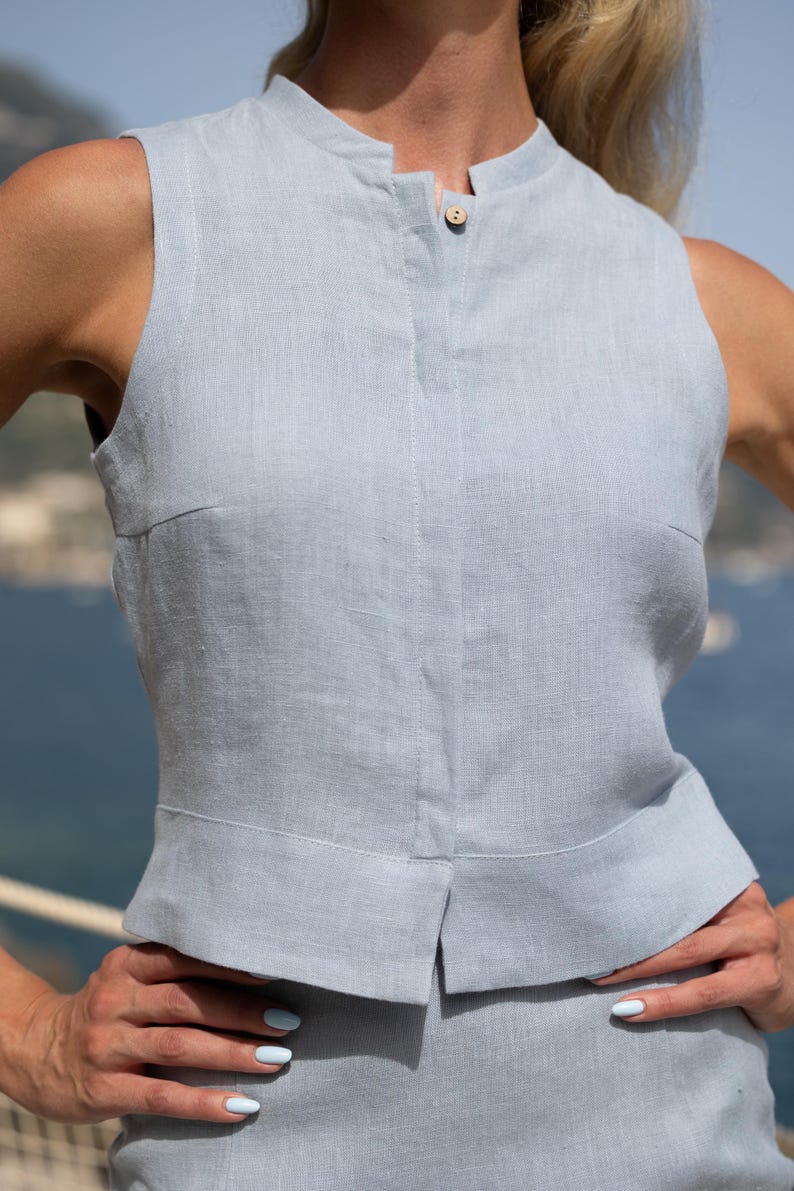 Dames mouwloze lichtblauwe linnen top gedragen bij zee